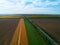 Aerial view of farmland and rows of crops. Taken from the air, looking down on a green field in summer