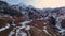 Aerial view of a fast upward movement in a valley above a road with snow