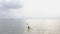 Aerial view: A female kayaker paddling in he serene ocean in an exotic island.