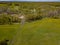 Aerial view of the field with green grass and yellow dandelions without people and garbage with forest and trees. Health and