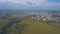 Aerial view of field with trees near the industrial area located outside the city. Clip. Amazing view of factories tanks