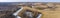 Aerial view of fields with copse, dry yellow grass, a stream, remnants of snow in early spring. Nature background.