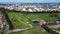 Aerial view of fields near oil refinery and buildings captured on a sunny day