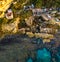 Aerial view of fishermen on the rocks, shacks and fishing posts on a cliff by the sea. Shelters and slums. Italian coast, Pizzo Ca