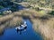 Aerial view of fishers and their fishing rods trying to catch fish on a small motor boat