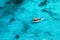 Aerial view of the fishing boat in transparent blue water