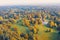 Aerial view flight over autumn valley park with meadows and a winding river, ponds, bright trees