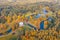 Aerial view flight over autumn valley park with meadows and a winding river, ponds, bright trees