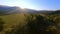 Aerial view flight over dense green trees tops autumn sunset sunny natural mountain valley landscape