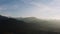 Aerial view flight over highland village lit with soft evening sun light. Drone shot beautiful mountain valley in warm