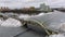 Aerial view flight tracking a moving rail train moving on a bridge over a freezing river