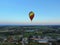 Aerial view flights in large balloons above the forest and field at sunset. Balloon festival. Beautiful landscape at sunset