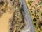 Aerial view of a flooded highway through a vast landscape of golden-hued terrain