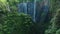 Aerial view fly through trees to Tumpak Sewu waterfall, Indonesia