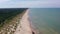 Aerial view flying along Latvian Baltic sea seaside beach coast. People on beach