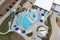 Aerial view from flying drone of aquapark, water park with various water slides, pool, sun loungers.