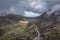 Aerial view of flying drone Epic landscape image in Autumn looking down Nant Fracon valley from Llyn Idwal with moody sky and