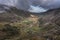 Aerial view of flying drone Epic landscape image in Autumn looking down Nant Fracon valley from Llyn Idwal with moody sky and