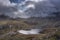 Aerial view of flying drone Epic landscape image of Llyn Bochlwyd in the mountains in Snowdonia National Park with dramatic sky