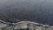 Aerial view, flying over coastline during a storm. Camera moving forwards above rocky shore and sea waves with foam