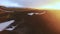 Aerial View. Flying over the green valley. Sunset in the mountains. Tourists by car