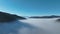 Aerial View. Flying over the high mountains in beautiful clouds. Aerial Drone camera shot. Air pollution clouds over