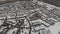 Aerial view flying over snow covered town street and houses during snowfall