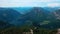 Aerial view of flying paragliders of white color parachutes from the snowy mountains in Austria.