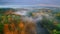 Aerial view of foggy river and colorful forest in autumn