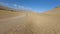 Aerial view follow speed riding black SUV automobile on sand road desert mountain sky horizon