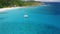 Aerial view footage of lonely luxury catamaran yacht moored in crystal clear turquoise blue ocean water of Petite Anse