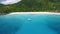 Aerial view footage of luxury catamaran yacht moored in clear turquoise blue ocean water of Petite Anse sandy beach of