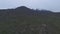 Aerial view of foothills then vertically panning to reveal snowcapped mountains and fog