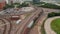 Aerial view of freight train on the tracks. Transport of good on railway corridor winding between highway and downtown