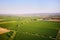 Aerial view of fresh green fields, village and farmland. Rural countryside and agriculture.