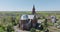 aerial view and full flyby over old new red bricks neo gothic temple or catholic church in countryside
