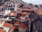 Aerial view of funchal in madeira showing red tiled roofs of old white buildings with the coast in the distance