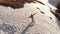 Aerial view girl athlete skier climbs on foot along the slope with a snowboard on his shoulders next to the kicker at a