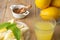 Aerial view of glass with lemon juice, plate with slices, mint, bowl with brown sugar and whole lemons, selective focus