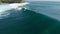 Aerial view of glassy waves in ocean and surfers. Surfing and waves