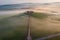 Aerial view of the goggy landscape at farmhouse Poggio Covili at sunrise in Val d\\\'Orcia, Tuscany, Italy