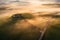 Aerial view of the goggy landscape at farmhouse Poggio Covili at sunrise in Val d\\\'Orcia, Tuscany, Italy