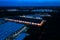 Aerial view of goods warehouse Night. Logistics center in industrial city zone from above. Aerial view of trucks loading at