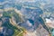 Aerial view of Grand Canyon Chonburi. Trucks dig coal mining or ore with black grunge ground in quarry with mountain hills. Nature