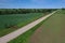 Aerial view of gravel road on farmland fields in spring