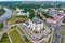 Aerial view from great height on red roofs of old city with heavy traffic on bridge with wide multi-lane road across wide river