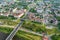 Aerial view from great height on red roofs of old city with heavy traffic on bridge with wide multi-lane road across wide river