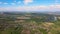 Aerial view of green cultivated agricultural fields with growing crops and rural village houses