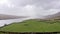 Aerial view of green farmland in Ireland. Irish rural landscape, panorama, cow, sheep, river on the left side, hills in