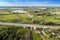 Aerial view of green fields, village, and highway